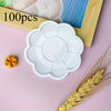 A white flower-shaped disposable paint palette is shown next to a stalk of wheat.