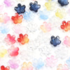 A collection of colorful cherry blossom flower glass beads in various shades of pink, blue, yellow, and orange.