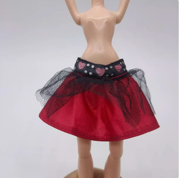 A fashion set for a doll featuring a red skirt with black lace trim and sheer netting.