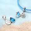 Sterling silver charm pendant set featuring blue gemstone and marine life charms on a blue beaded necklace