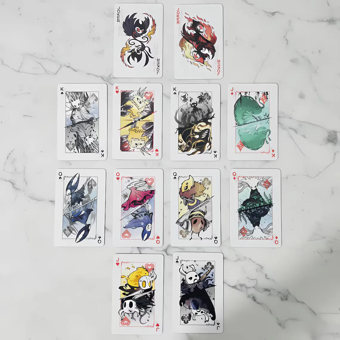 A collection of black and white poker-style cards featuring characters from Hollow Knight.