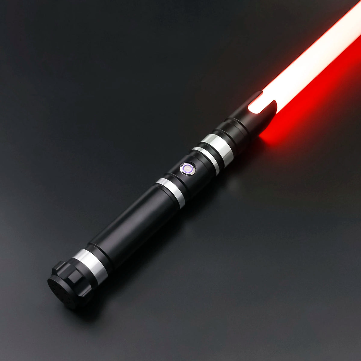 A black lightsaber with a red glowing blade and silver accents is shown diagonally on a dark surface.