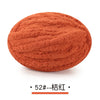 A ball of orange-red chunky chenille yarn for hand knitting projects.