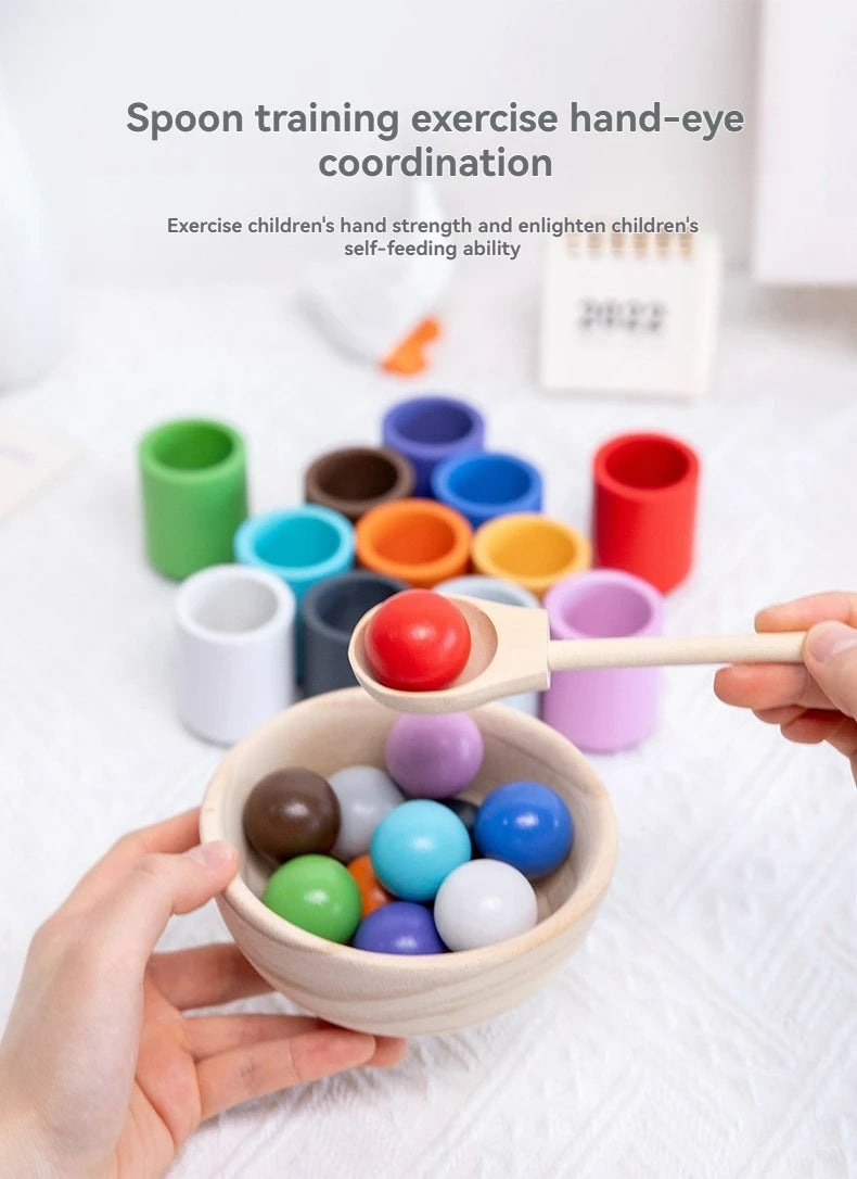 Hands are using a wooden spoon to transfer colorful balls from a bowl, demonstrating hand-eye coordination training.