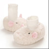 A pair of soft, white, cartoon baby booties with pink ears and a white cuff.