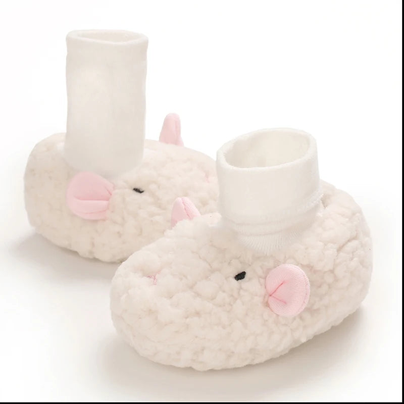 A pair of soft, white, cartoon baby booties with pink ears and a white cuff.