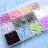 A clear plastic box filled with various colors of glass beads, including pinks, purples, greens, and clear tones.