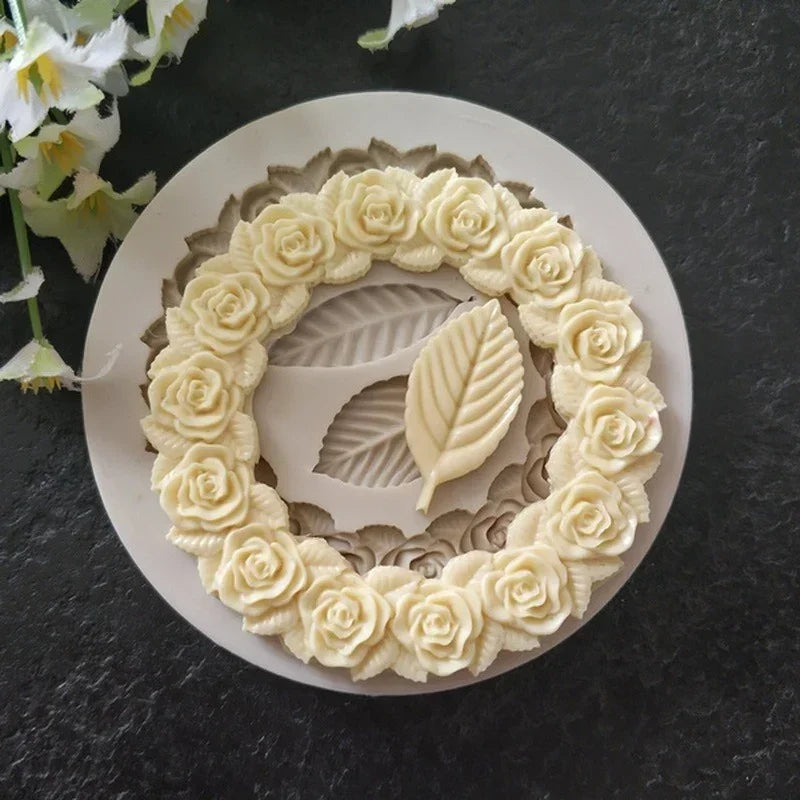 A white silicone mold shaped like a wreath of rose leaves for cake and chocolate decorating