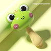 A bright green frog sand hammer toy with large eyes and a light beige handle.