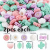 A collection of pink, purple, and mint green silicone flower and leaf beads for jewelry making.