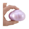 A hand is holding a smooth, translucent purple squishy cube for stress relief.