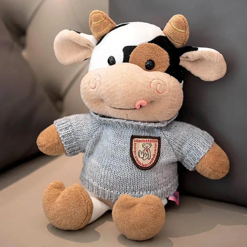 A soft plush cow doll with white and brown markings, sitting on a light surface.