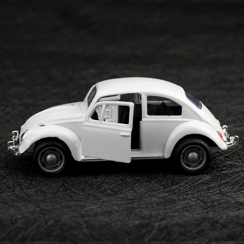 A white 1:38 die-cast model of a classic Beetle car shown in profile on a dark surface.