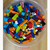 A clear plastic container filled with assorted colorful building blocks for a creative STEM toy set