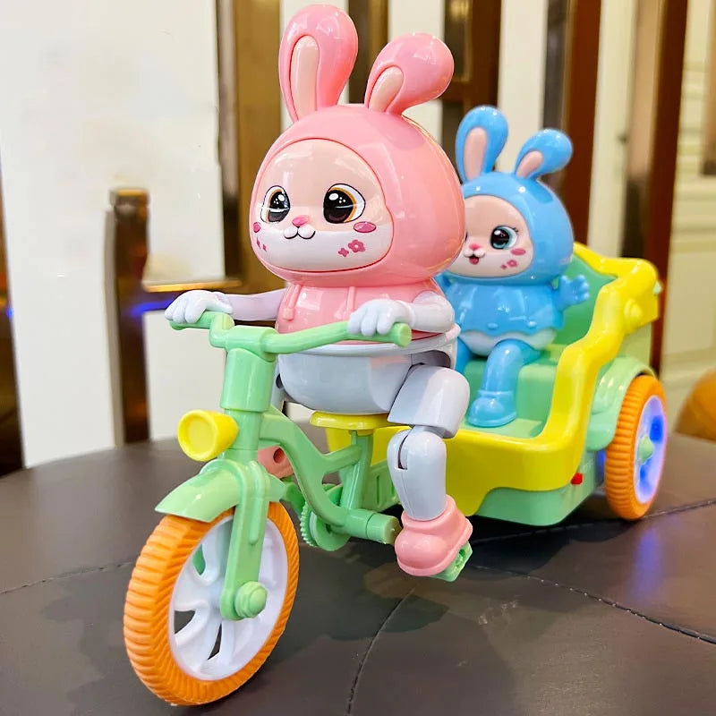 A pink rabbit plush toy is seated on a green electric tricycle with yellow accents.