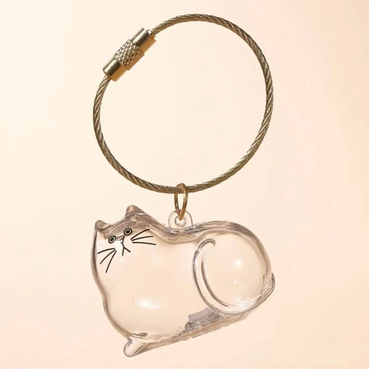 A clear, dog-shaped glass charm attached to a braided gold-colored cord.
