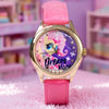 A pink My Little Pony magic sweetheart blind box watch with a gold-tone case and pink strap resting on a pink fuzzy surface.
