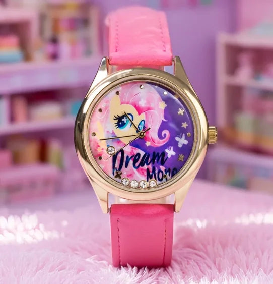 A pink My Little Pony magic sweetheart blind box watch with a gold-tone case and pink strap resting on a pink fuzzy surface.