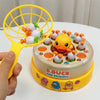 A yellow fishing net toy is shown with white and green balls, next to a round yellow game board featuring ducks and friends.