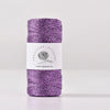 Purple metallic yarn in a skein for knitting and crochet with a white label
