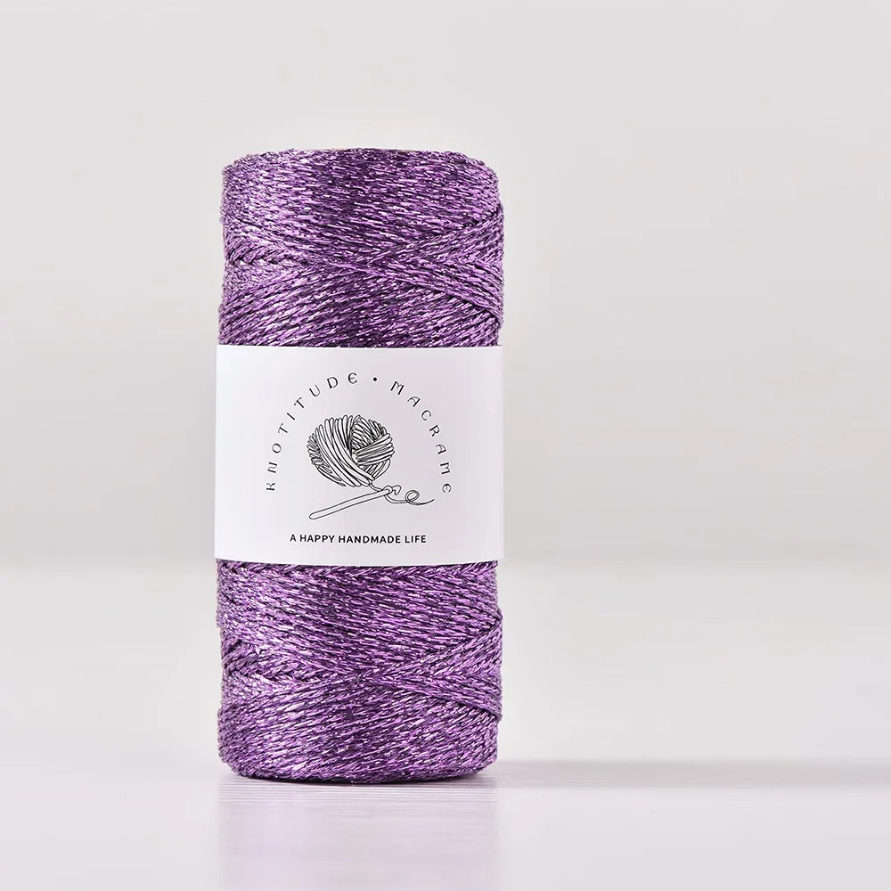 Purple metallic yarn in a skein for knitting and crochet with a white label