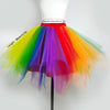 A vibrant rainbow tulle tutu skirt with a ruffled hem and a matching feather headband displayed on a mannequin.