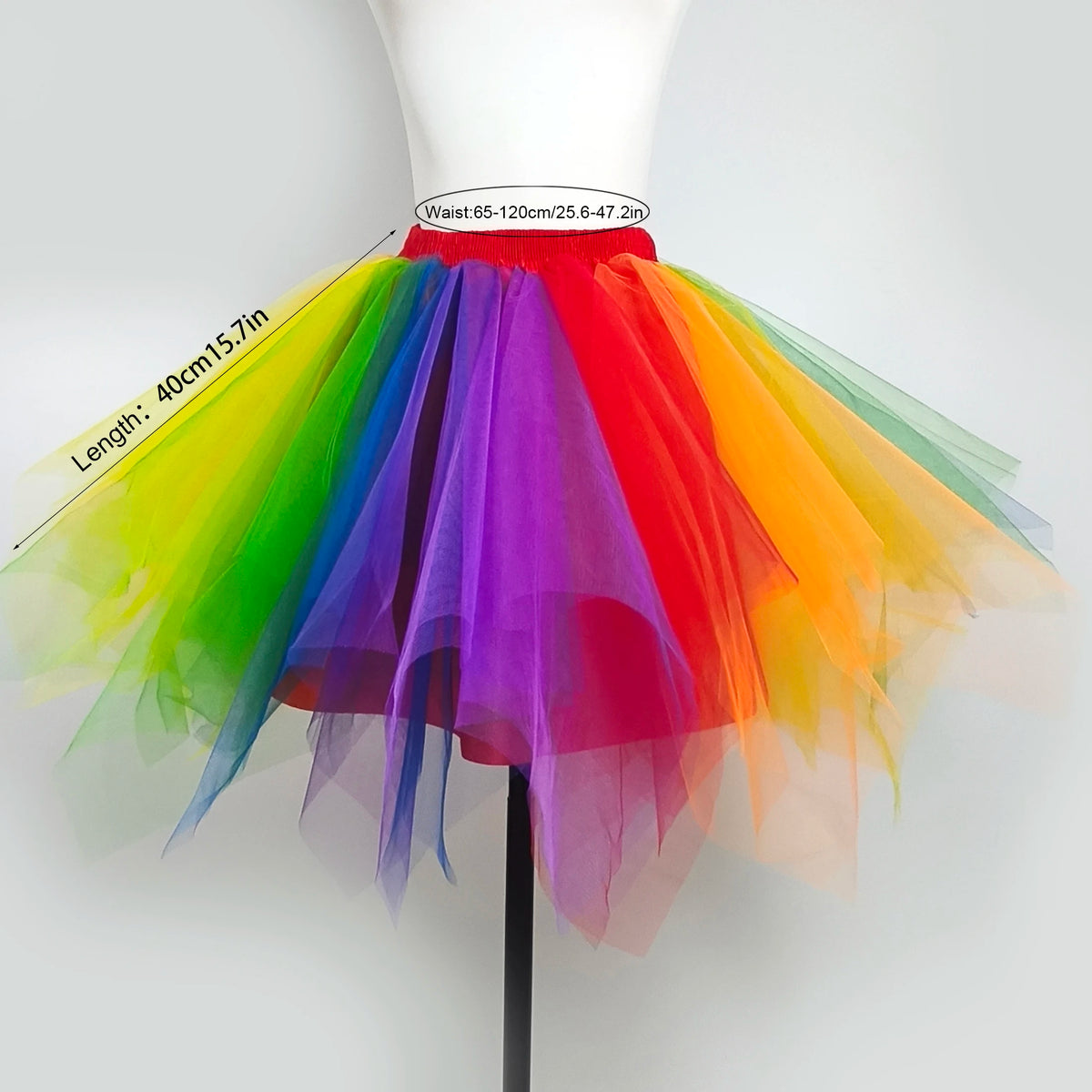 A vibrant rainbow tulle tutu skirt with a ruffled hem and a matching feather headband displayed on a mannequin.
