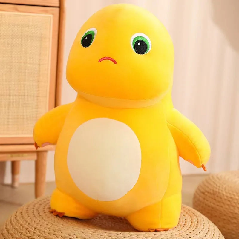 A bright yellow, smiling dinosaur plush toy with a white belly sitting on a woven surface.