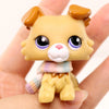A miniature pet animal figure with light yellow fur, large purple eyes, and a knitted accessory.
