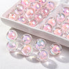 A white dish holds numerous pink and iridescent acrylic craft beads for jewelry making.