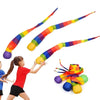 A colorful, flexible delta kite with a long tail is shown being held by a child.