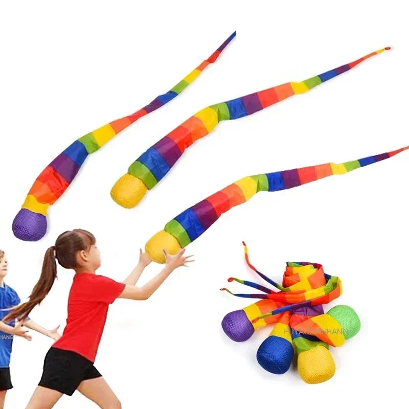 A colorful, flexible delta kite with a long tail is shown being held by a child.