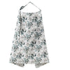 A white and blue botanical print muslin nursing cover with an adjustable neckline.