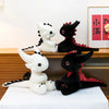 A display of two black and white Toothless dragon plush toys sitting on a wooden shelf.
