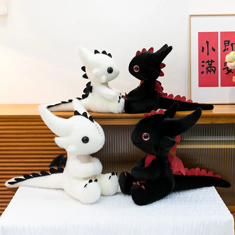 A display of two black and white Toothless dragon plush toys sitting on a wooden shelf.
