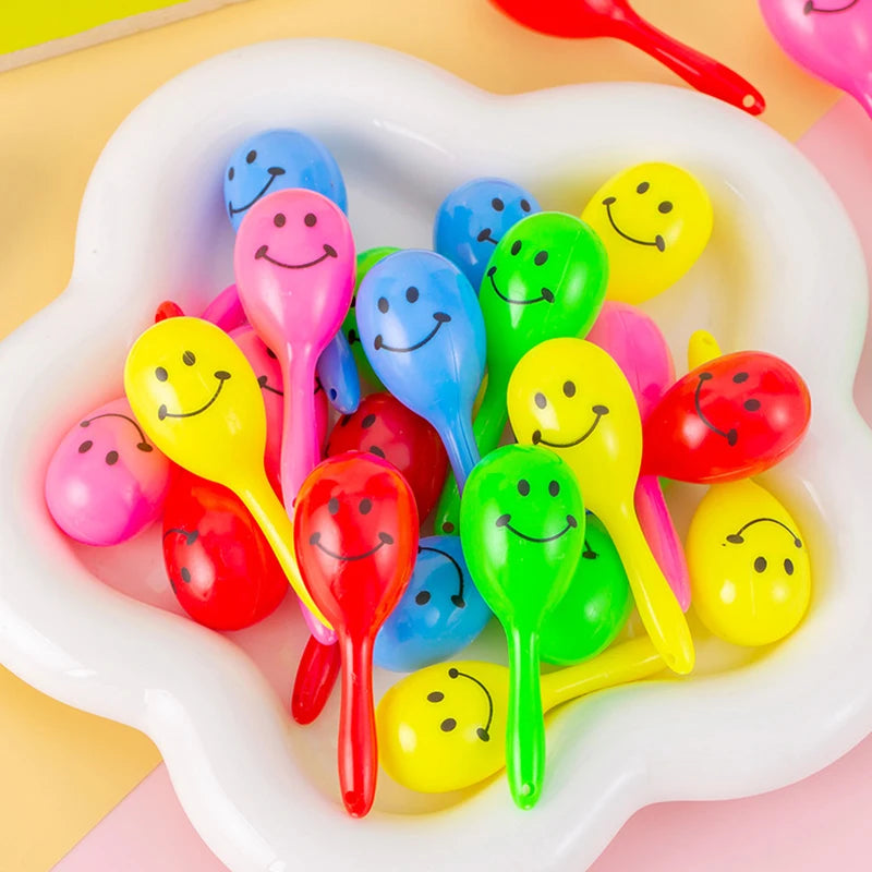 A collection of colorful mini maracas shaker toys in various bright colors, including yellow, pink, green, and blue.