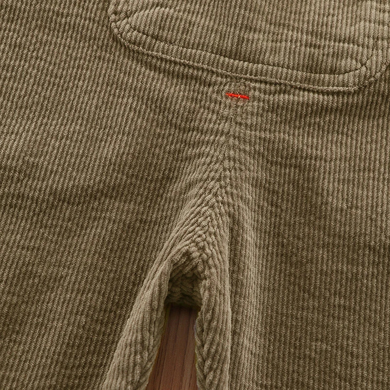 Close-up of olive green baby cotton overalls showing the stitching and adjustable strap detail.