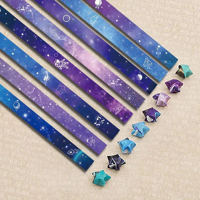 A collection of 27 iridescent star-shaped strips in various colors laid diagonally on a light background.