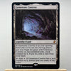 A Magic: The Gathering card named Gemstone Caverns showing a dark cavern landscape