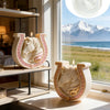 A white ceramic candle mold shaped like a horse with Celtic knot detailing sits on a wooden shelf next to a window view.