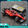 A red 1/64 formula racing RC car model with a black box and accessories on a gray surface.