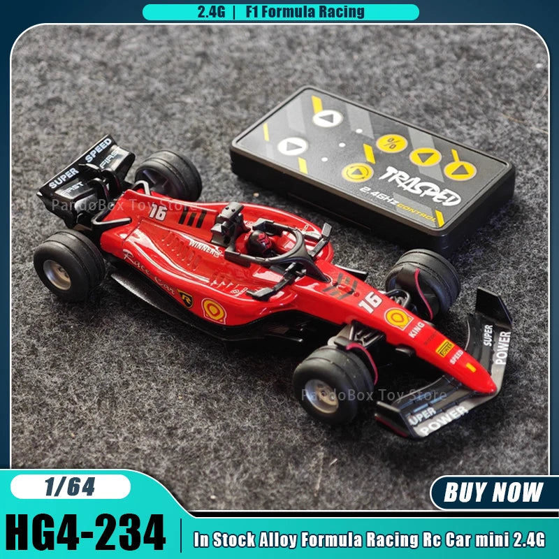 A red 1/64 formula racing RC car model with a black box and accessories on a gray surface.