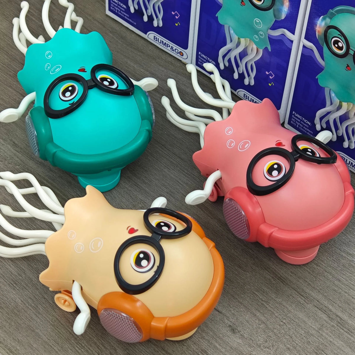 Three colorful interactive dancing jellyfish toys with lights and music are displayed on a gray surface.