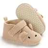 A pair of beige soft cotton baby walking shoes with anti-slip soles shown from the side.
