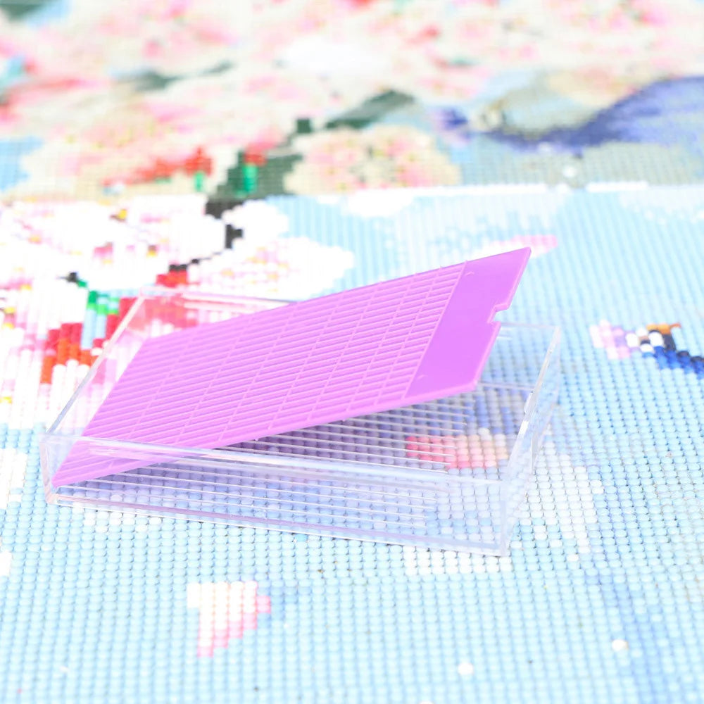 A clear plastic storage tray with a lid is shown resting on a light blue textured surface.