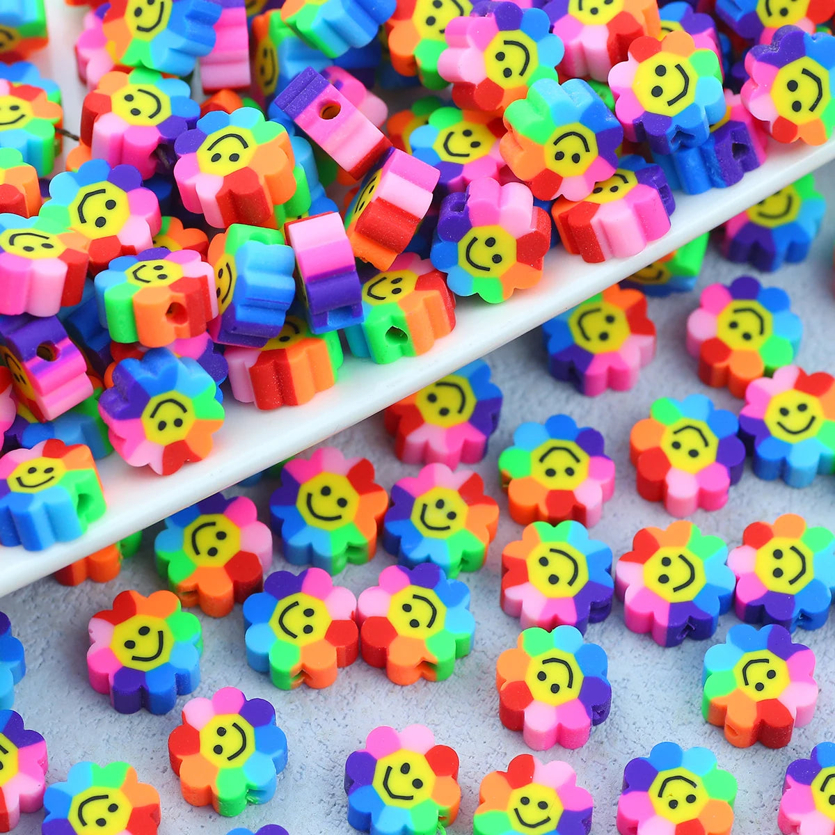A collection of colorful polymer clay smiling sunflower beads for jewelry making