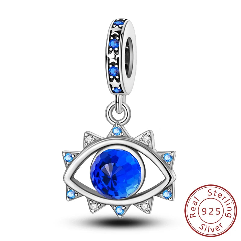 Sterling silver charm beads set featuring cross, angel, and evil eye designs with blue stones