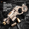 A small, silver alloy stress-relief pistol model with ejecting shell and a separate fidget spinner component on a dark surfac