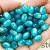 A handful of bright turquoise blue resin starry sky cat's eye beads for jewelry making