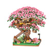 A miniature tree structure built from building blocks covered in pink blossoms and featuring a light.